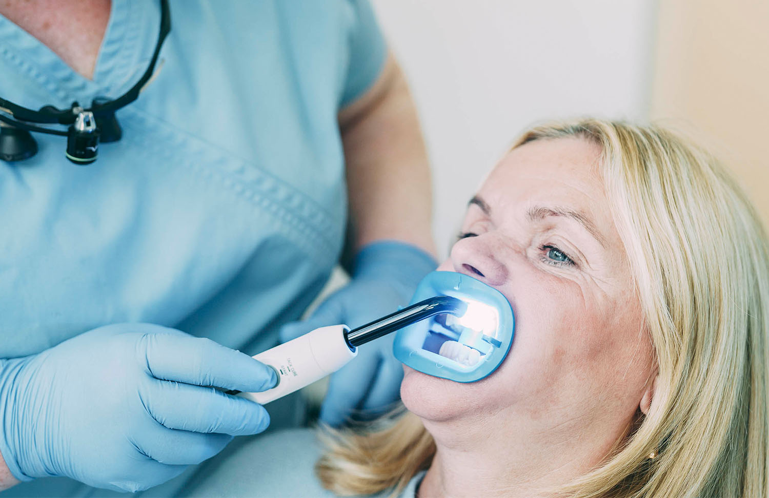 Eine Mitarbeiterin führt eine Bleaching-Methode bei einer Patientin durch bei den Zahnärzten am Lutherplatz in Langen.