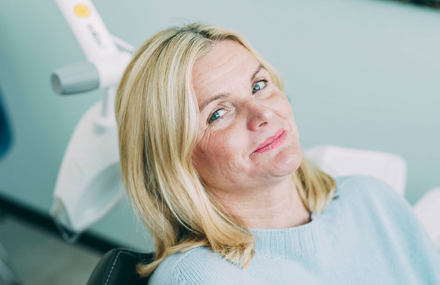Eine Patientin lächelt in die Kamera vor einer ästhetischen Behandlung ohne Metall bei den Zahnärzten am Lutherplatz in Langen.