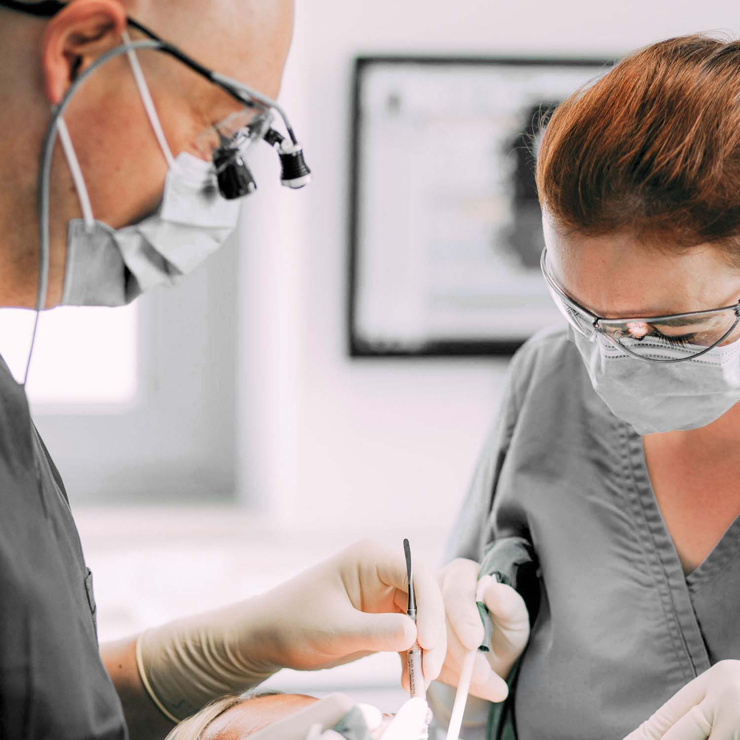 Herr Dr. Greßbach und eine Mitarbeiterin in einer während einer Behandlung bei den Zahnärzten am Lutherplatz in Langen.