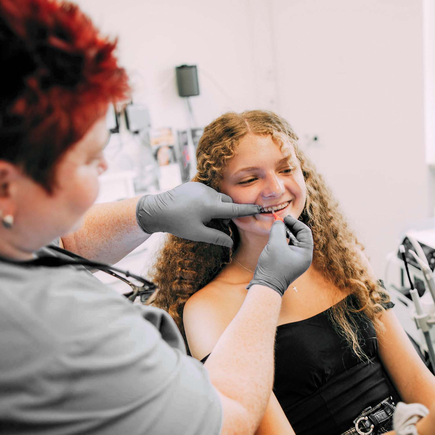 Ein jugendliche Patientin lächelt während einer professionellen Zahnreinigung bei den Zahnärzten am Lutherplatz in Langen.