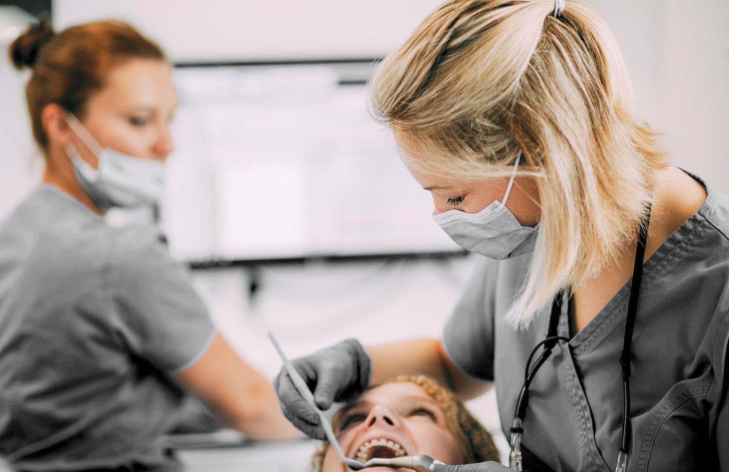 Zwei Mitarbeiterinnen der Praxis in einer Veneeers-Behandlung bei den Zahnärzten am Lutherplatz in Langen.