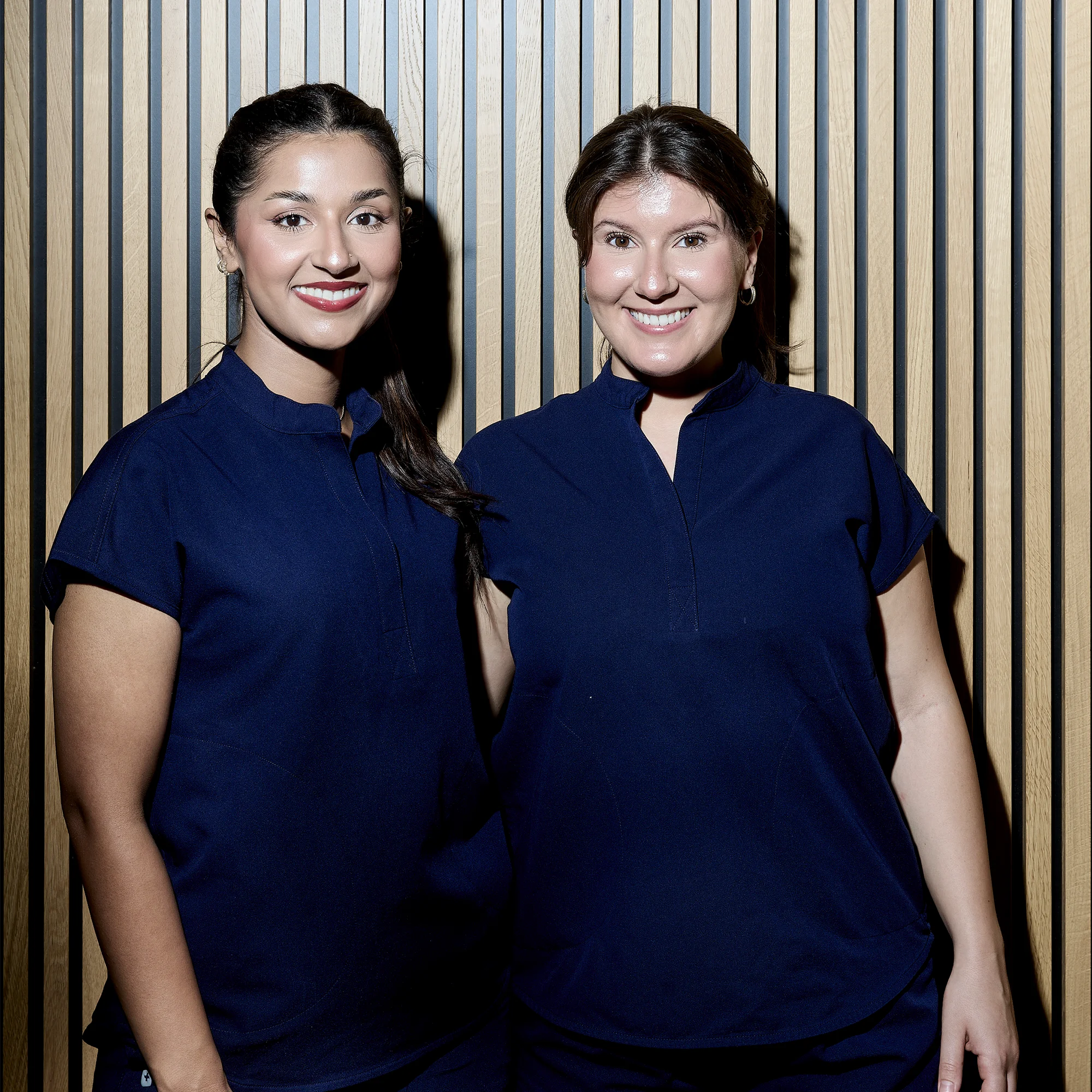 Zwei Zahnärztinnen in blauer Praxisuniform im Team der Zahnärzte für Endodontologie