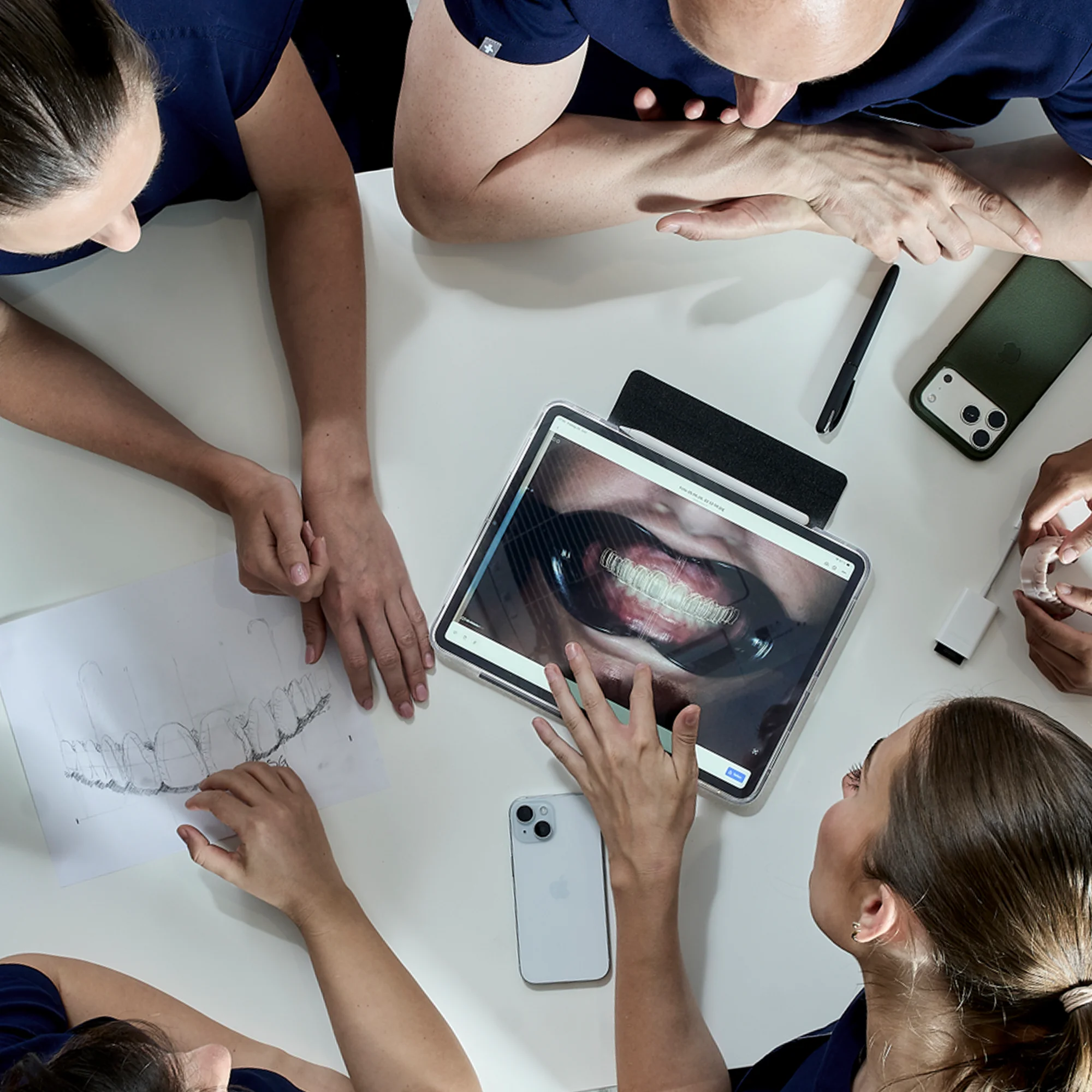 Zahnärztliches Team prüft ein digitales Röntgenbild am Tablet zur Behandlung gesunder Zähne